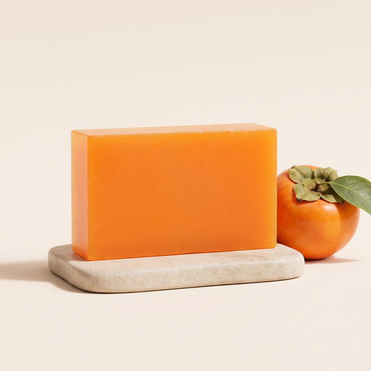 Savon au kaki Kyora sur pierre avec un kaki frais